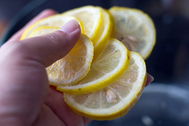 istock Fresh slices of Lemons in hand 831884152