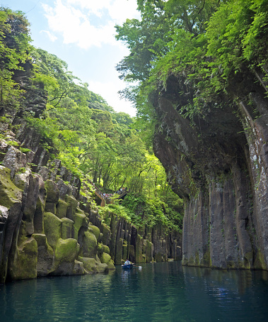 Boating on Takachiho canyon, basalt colunms, river and green forest reflecting on water, waterfall, Takachiho, Japan