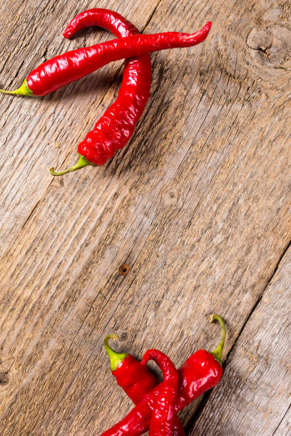 istock Chili. Red chili peppers on wooden table. Selective focus. 831892164