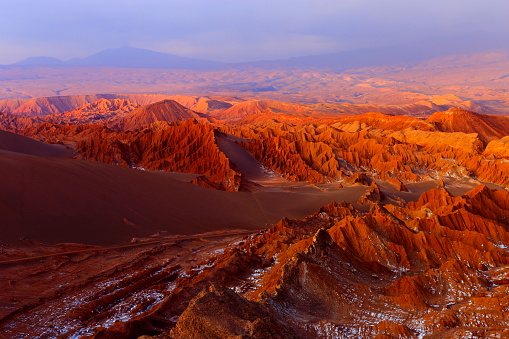 Atacama Desert Moon valley – Valle de La luna and Valle de La muerte – Death Valley – above dramatic ethereal pastel colored moon surface landscape at gold clored sunset, exotic volcanoes and Idyllic Atacama Desert, Volcanic landscape panorama –  Chile, Bolivia and Argentina border