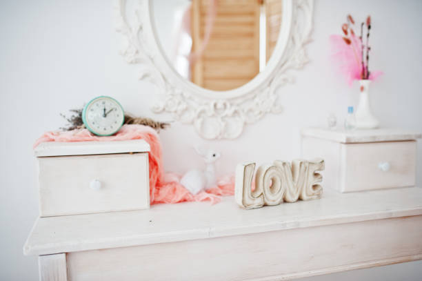 istock Vintage commode with clock and other decorations on top of it and a mirror on the wall. 831900274