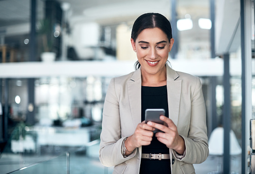 Shot of a businesswoman using a mobile phone in a modern office