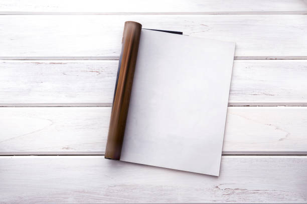 istock The Opened empty white mock up magazine page on white wooden table background 831909504