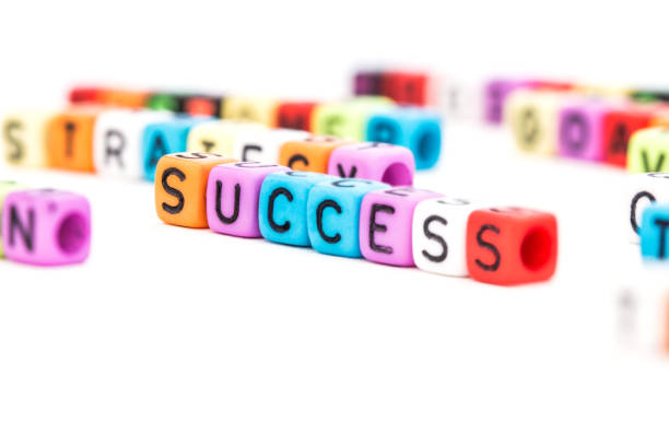 istock the colorful SUCCESS english alphabet cube on white background , selective focus 831934410