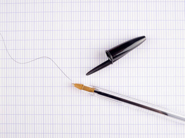 istock Black ballpoint pen on a large checkered sheet 831945172