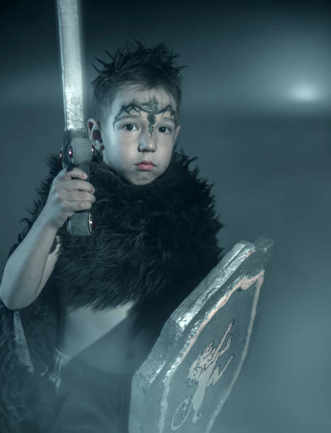 istock Portrait of Serious Boy Warrior with Sword and Shield 831945856