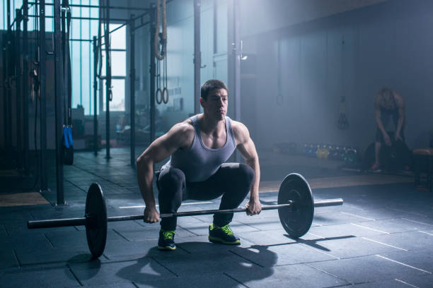 istock Young athlete man and women doing exercise with weights in gym 831953918