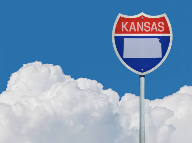 istock Highway sign for Interstate road in Kansas with map in front of clouds 831955252