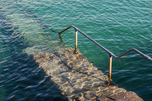 Stairs in clear water of the ocean, Cornwall, England.