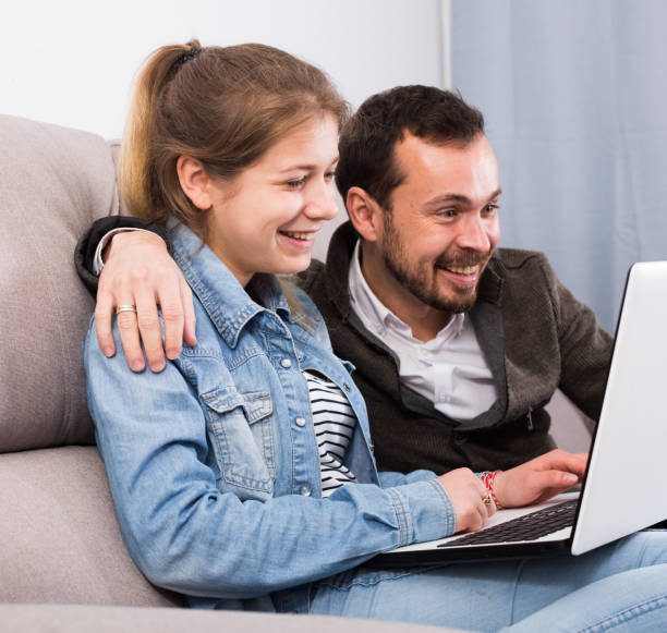 istock Father and daughter booking online 831961684
