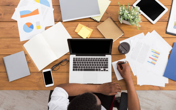 istock African-american businessman at work, table top view 831970628