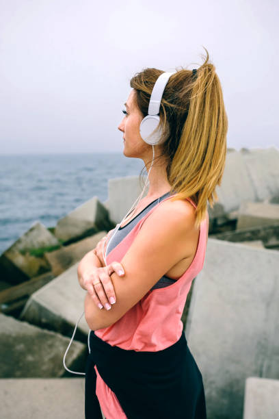 desportista com fones de ouvido, olhando o mar - short phrase audio - fotografias e filmes do acervo