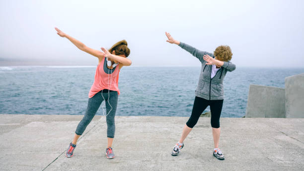 Women making dab dance outdoors Senior and young woman making dab dance outdoors by sea pier dab dance photos stock pictures, royalty-free photos & images