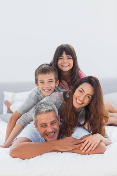 istock Parents with their children lying on bed 831978164
