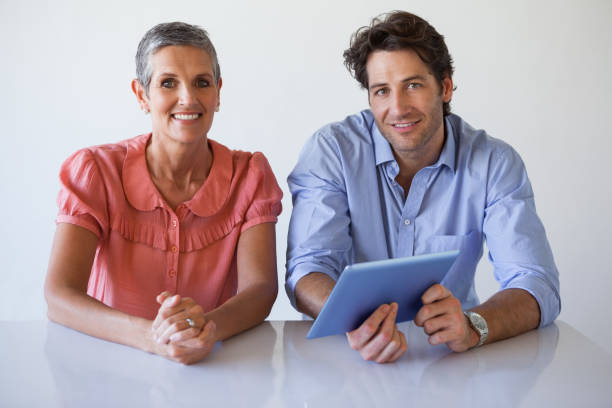 istock Casual smiling business team working at desk using tablet 831978748