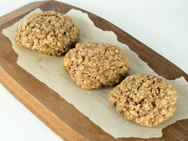 istock Oat cookies over wooden plate with white background 831979166
