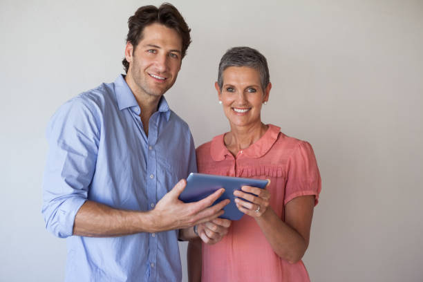 istock Casual smiling business team looking at tablet pc together 831979490