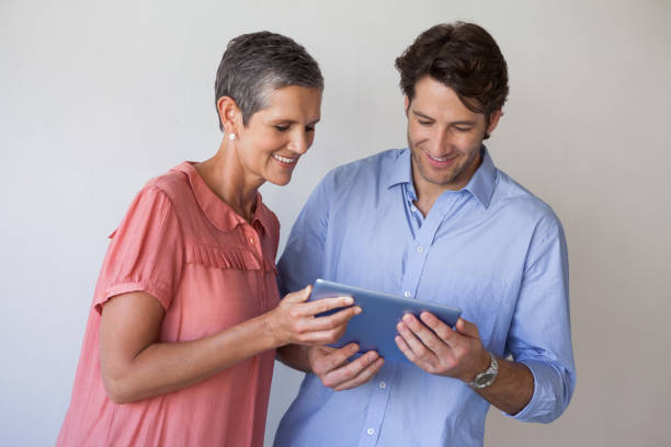 istock Casual smiling business team looking at tablet pc together 831979578