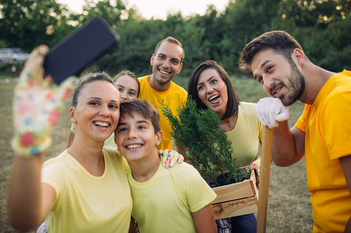 Photo of group of volunteers takes selfie in the park