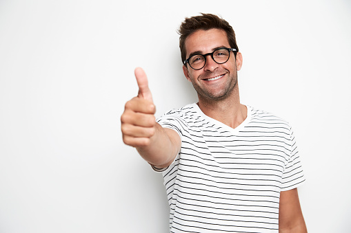 Thumbs up dude smiling at camera, studio