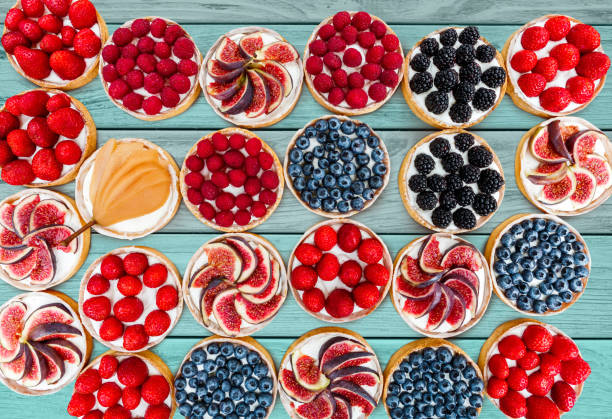 istock Fruit and Berry tarts dessert assorted top view background 831993230