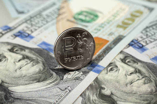 One ruble coin on dollar banknote. Closeup, macro shot stock photo