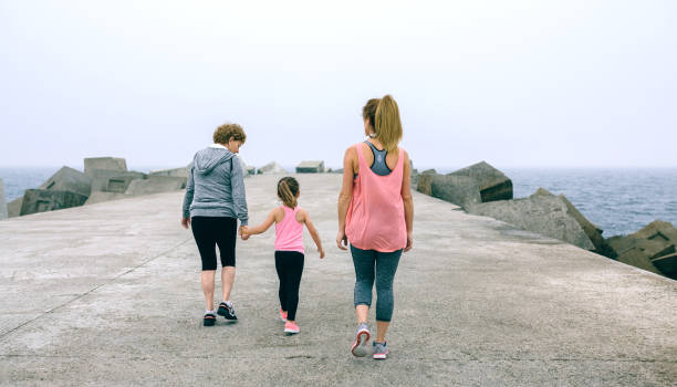 istock Back view of three female generations walking 832007520