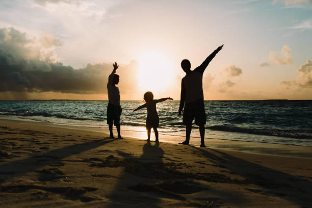 istock father with son and daughter silhouettes play at sunset beach 832026316