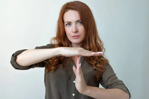 Young woman showing time out hand gesture Too many things to do. Human emotions face expression reaction