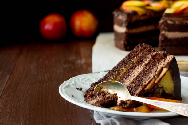istock Piece of chocolate cake with nectarines on white dish 832043324