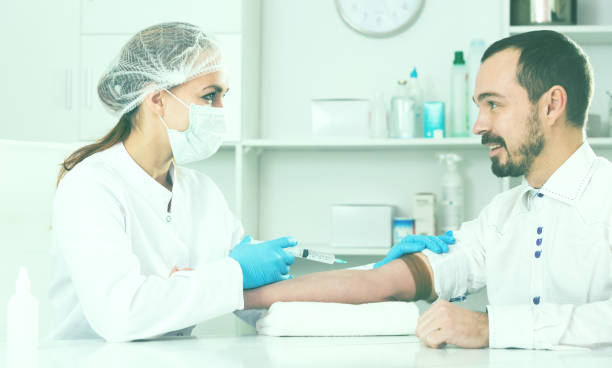 istock Female nurse injecting male patient 832050218