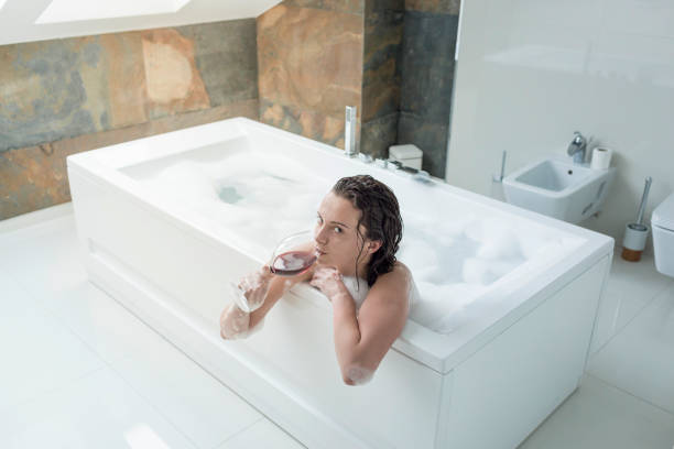 istock Relaxed woman drinking wine in bathtub 832071682