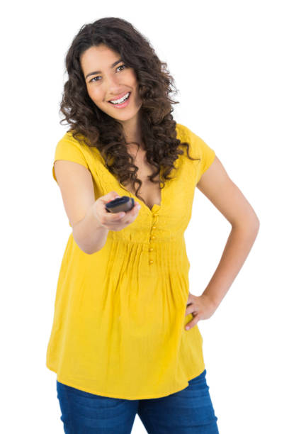 istock Smiling curly haired pretty woman changing channel with remote 832073284