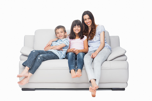 Mother with their children sitting on sofa on white background