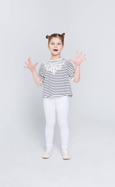 istock Amazed cute little girl showing her palms on white studio background 832082392