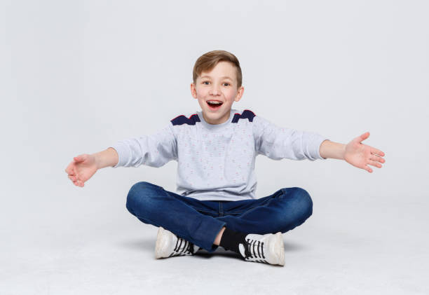 istock Happy laughing boy sitting on the studio floor 832084946