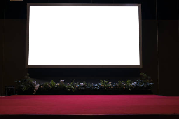 istock projector screen on stage with red carpet in conference hall. 832085066