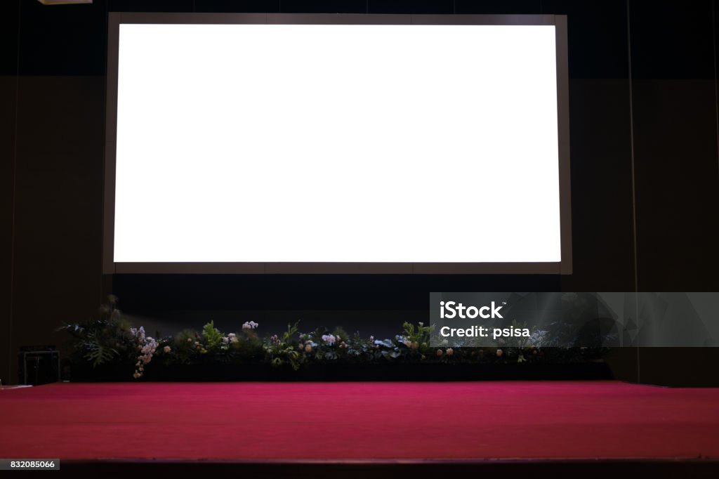 projector screen on stage with red carpet in conference hall. blank projector screen on stage with red carpet in conference hall. Stage - Performance Space Stock Photo