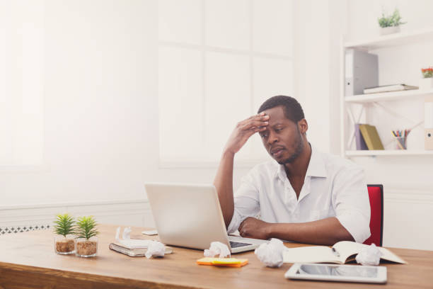 istock Tired black businessman in office, work with laptop 832089142