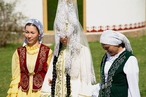 Almaty, Kazakhstan - September 18, 2011: Unidentified lady (in the center) wears traditional Kazakh wedding dress in Almaty, Kazakhstan.