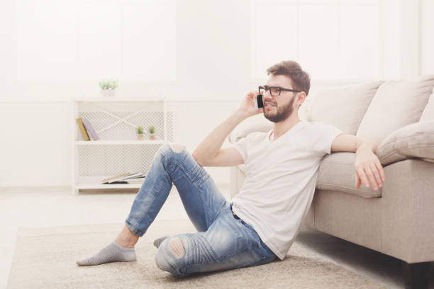 istock Man in glasses at home with mobile 832092504