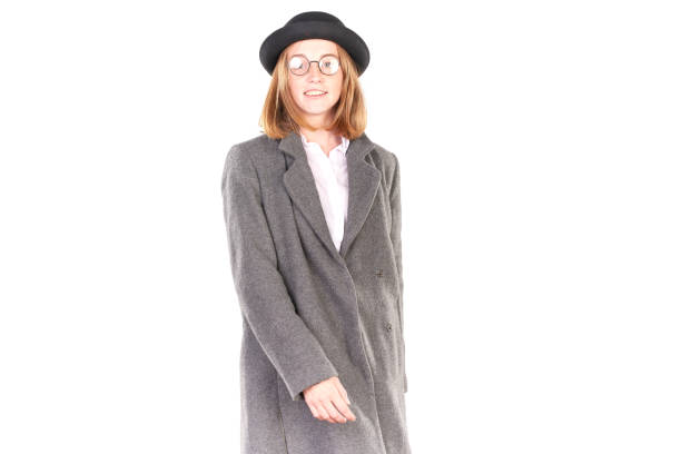 Portrait of teenage hispter girl wearing gray overcoat and black hat isolated on white