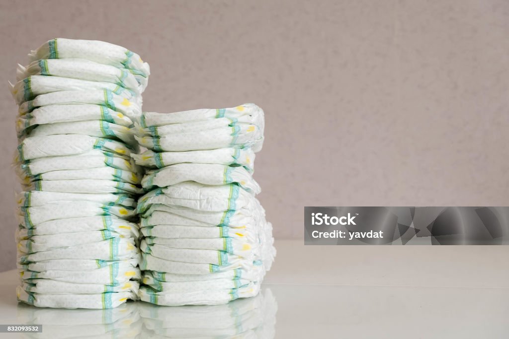 Diapers. Isolated. Baby care. Studio Shot. Stacks of diapers for children isolated on white background. Stack of baby disposable diapers Stack of baby disposable diapers and Pacifier over white background Diaper Stock Photo