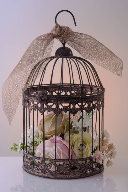 istock Artificial large flowers in a decorative gold birdcage. 832096946