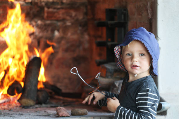 istock A boy stand in front of a fire with a braai thong in his hand 832099716