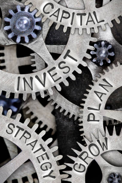 Metal Wheel Concept Macro photo of tooth wheel mechanism with INVEST, CAPITAL, STRATEGY, PLAN and GROW concept letters capital budget pictures stock pictures, royalty-free photos & images