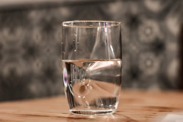 istock Modern glass of water sitting on a table with blured background 832105110