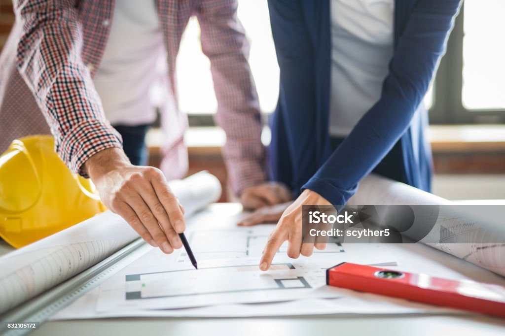 Architects working with blueprints in the office. Architects working with blueprints in the office. Teamwork architects concept. Planning Stock Photo