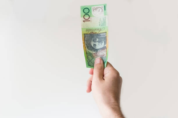 Man holding one hundred Australian Dollar note in his hand stock photo