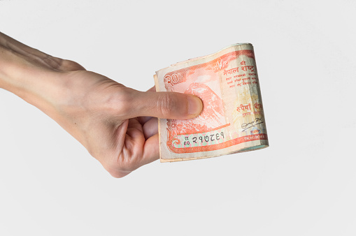 Woman holding Nepal Rupees banknotes in her hand